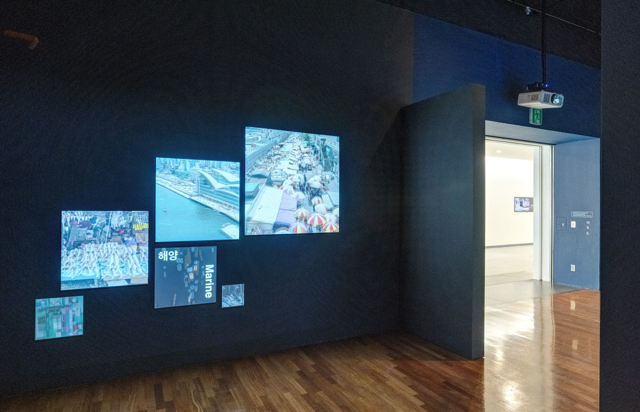 Busan’s Gukje Market (right) is shown on display monitors at the exhibition. (National Folk Museum of Korea)