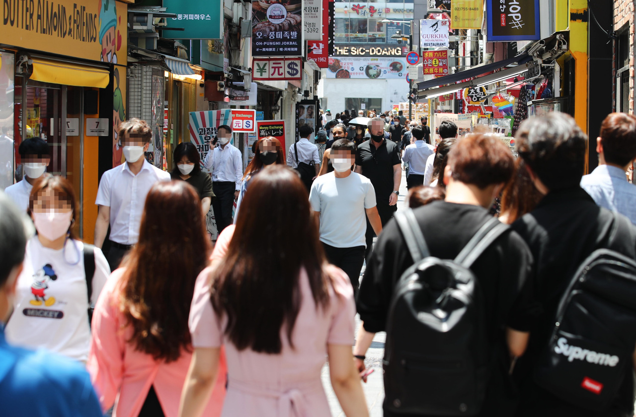 Pedestrians walk through Myeong-dong shopping district in Seoul on Monday. (Yonhap)