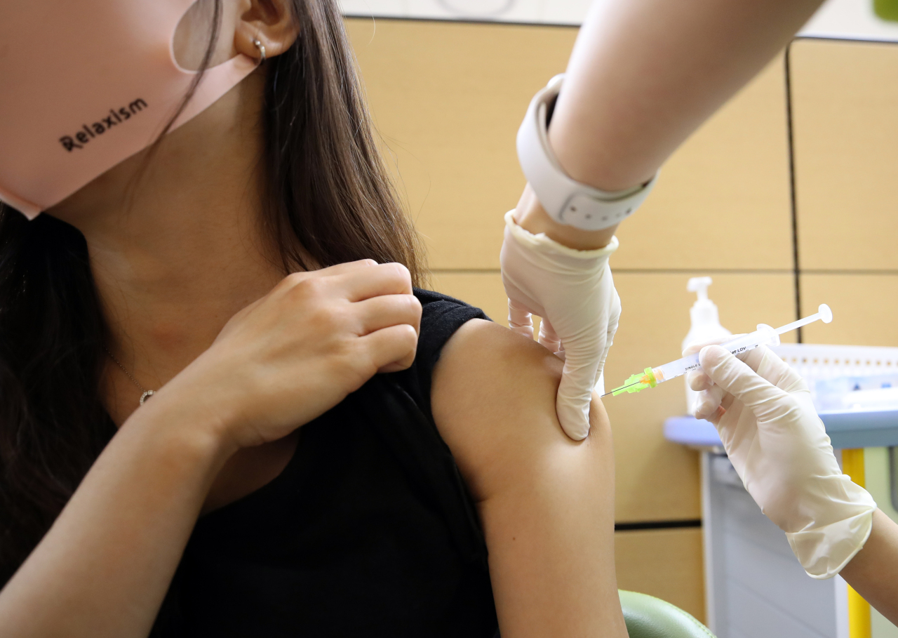 A health worker gives a COVID-19 vaccine shot to a citizen at a local hospital in Seoul. (Yonhap)