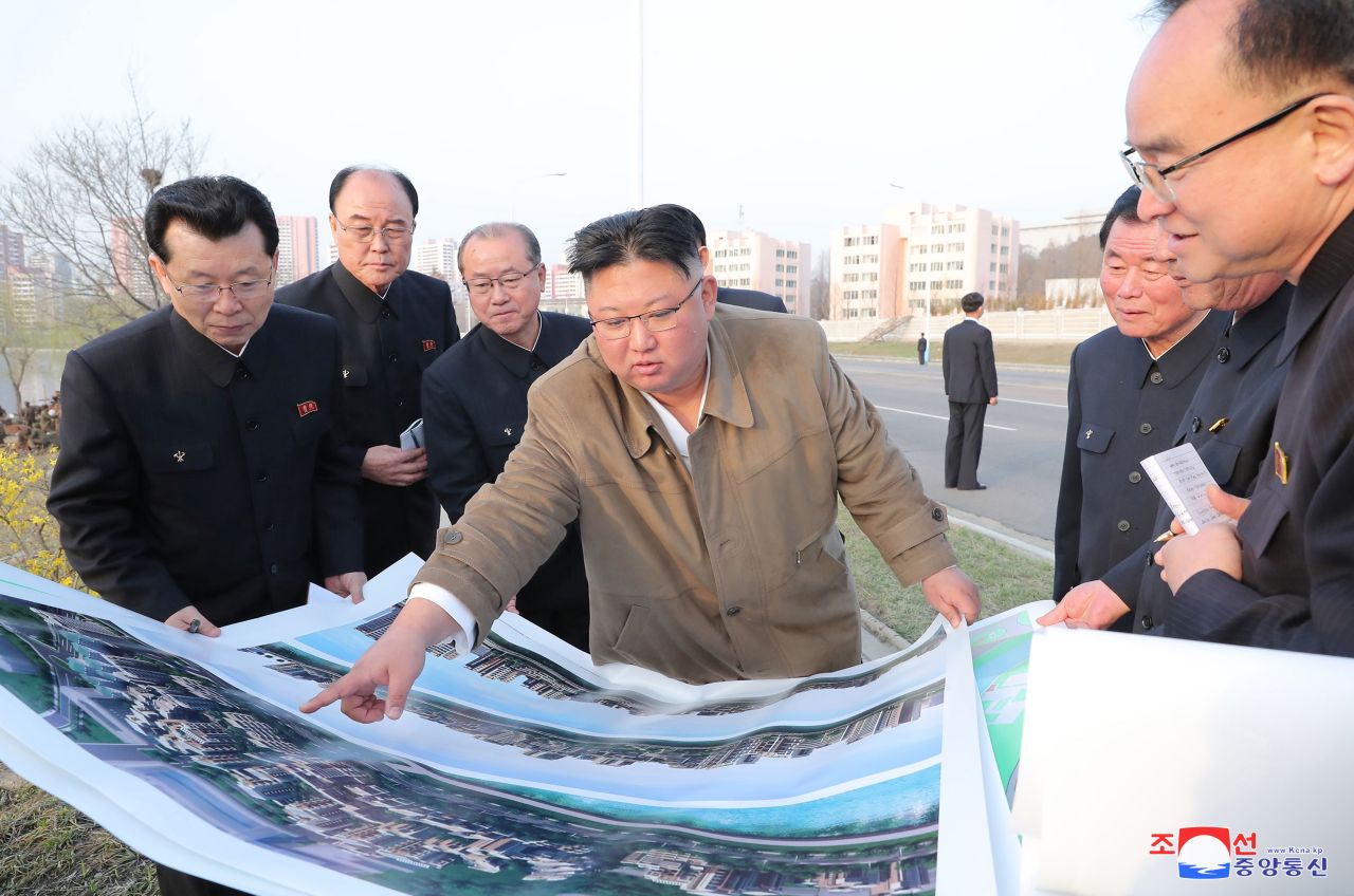This photo, released by the Korean Central News Agency, shows North Korean leader Kim Jong-un (C) giving an order to officials of the North's Workers' Party while looking at a rendering of a residential district for terraced apartments to be built on the banks of the Pothong River in Pyongyang during an inspection of the construction site on March 31, 2021. It was his second inspection of the site following one about a week ago. (Korean Central News Agency)