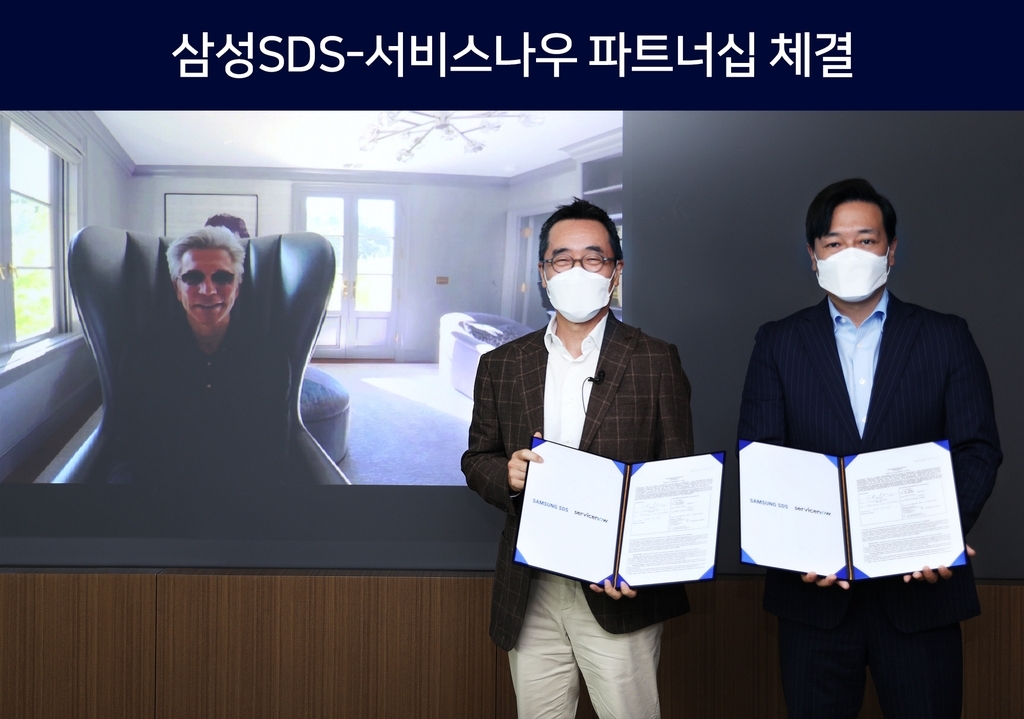 This photo provided by Samsung SDS Co. on Tuesday, shows the company's CEO Hwang Sung-woo (C) posing for a photo with ServiceNow CEO Bill McDermott (L) and ServiceNow Korea chief Kim Gyu-ha (R) after signing a partnership at the company's office in Seoul. (Samsung SDS Co.)