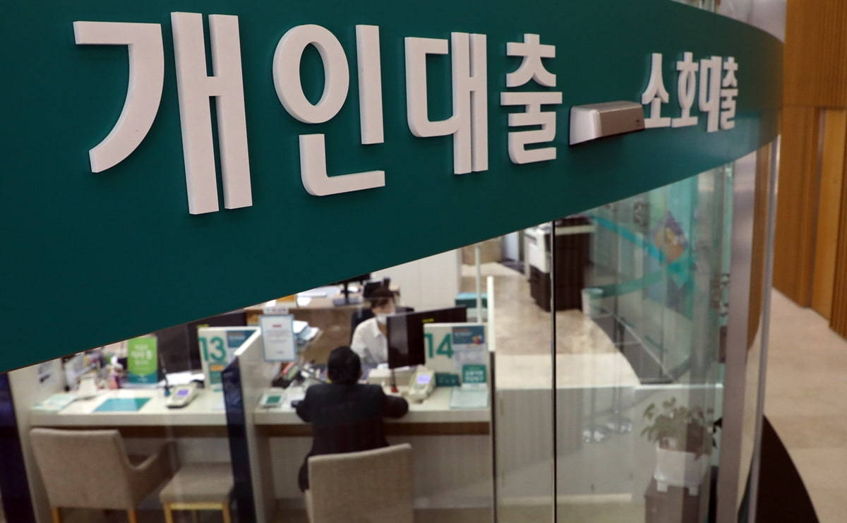 This file photo shows a bank official explaining a loan product to a visiting customer. (Yonhap)