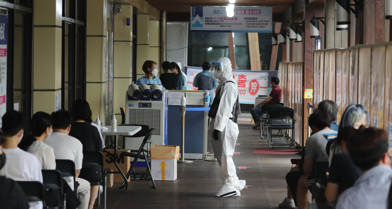 People wait to get tested for COVID-19 at a public health center in Seoul on Wednesday. (Yonhap)