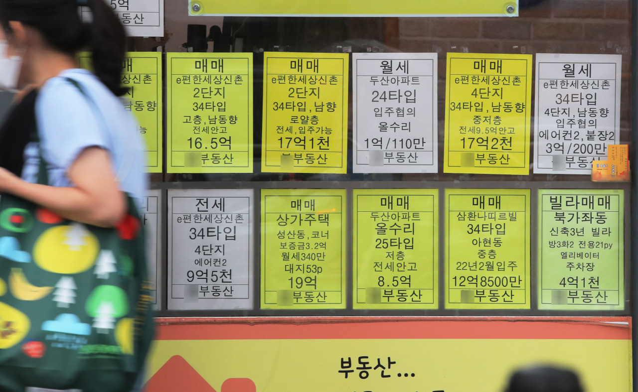 A pedestrian passes by a real estate office in Seoul, Wednesday. (Yonhap)