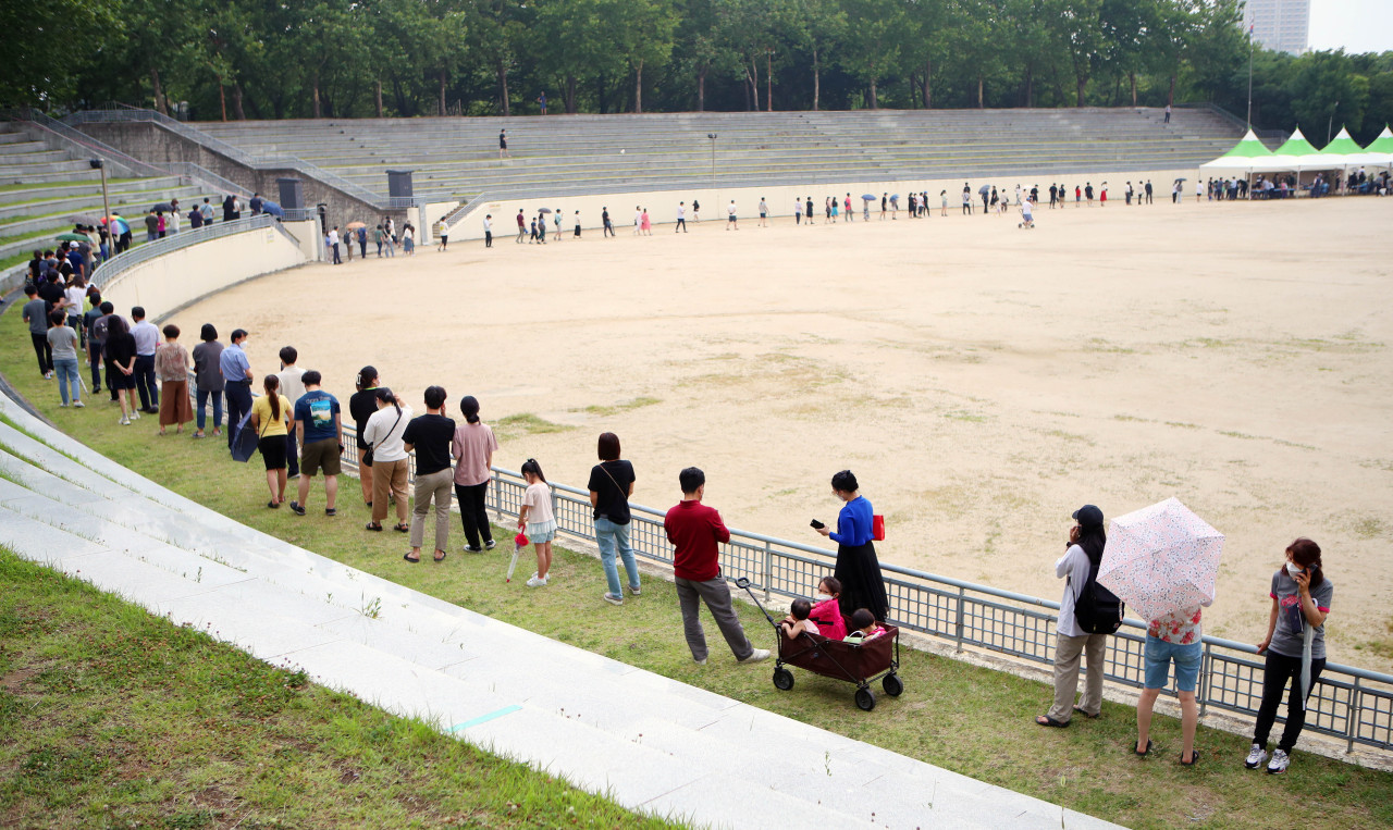 People wait in line to be tested for COVID-19 at a testing center in Daegu, 302 kilometers south of Seoul, on Wednesday. (Yonhap)