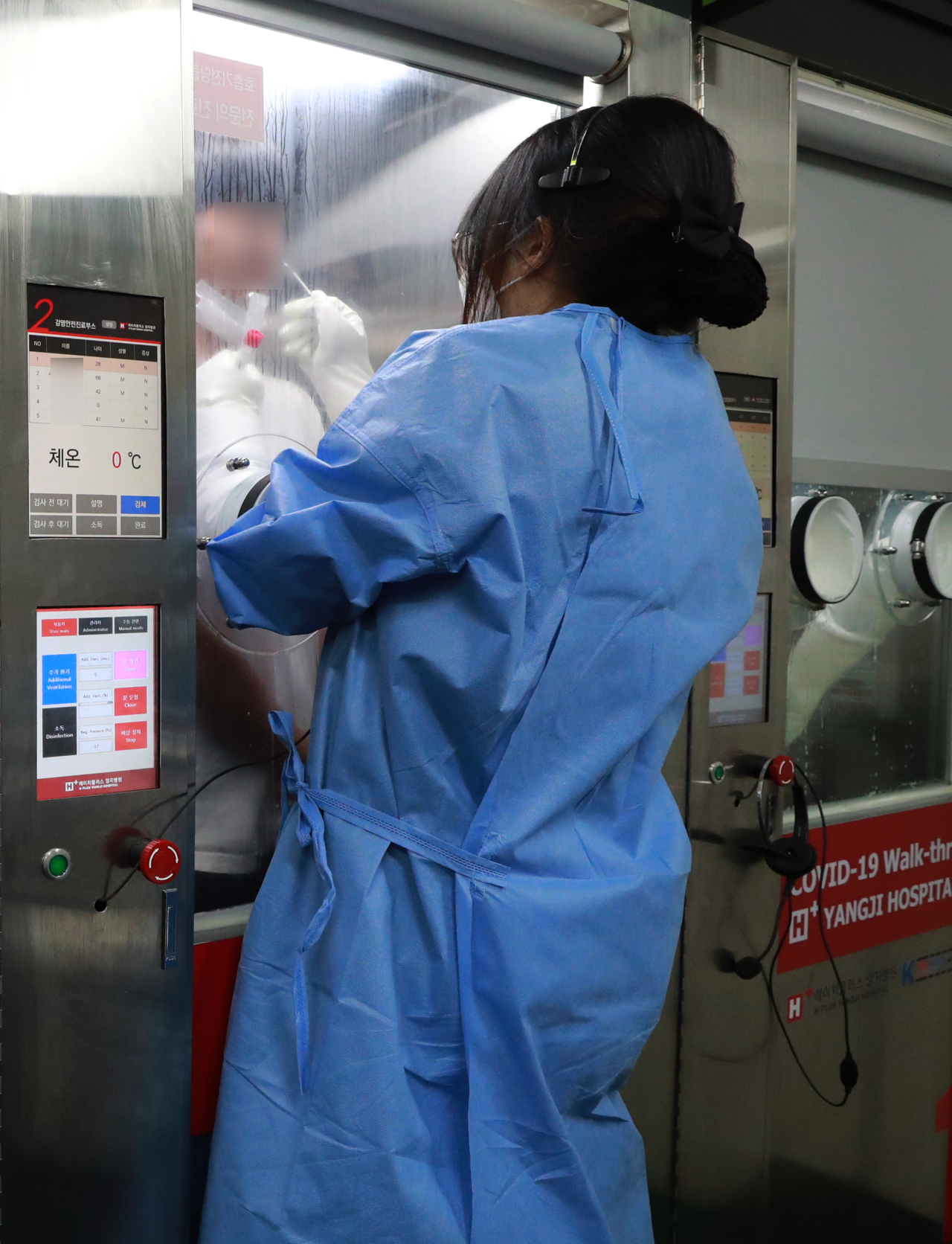 A medical worker takes a sample from a citizen at a COVID-19 walk-thru testing station in Seoul on July 5, 2021, when the country reported 711 new infections, including 67 from abroad. (Yonhap)