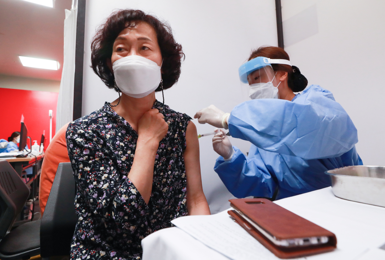 A woman, who has had an AstraZenaca vaccine shot, receives a Pfizer shot at a hospital in Seoul on Monday, as the nation introduced cross vaccinations. (Yonhap)