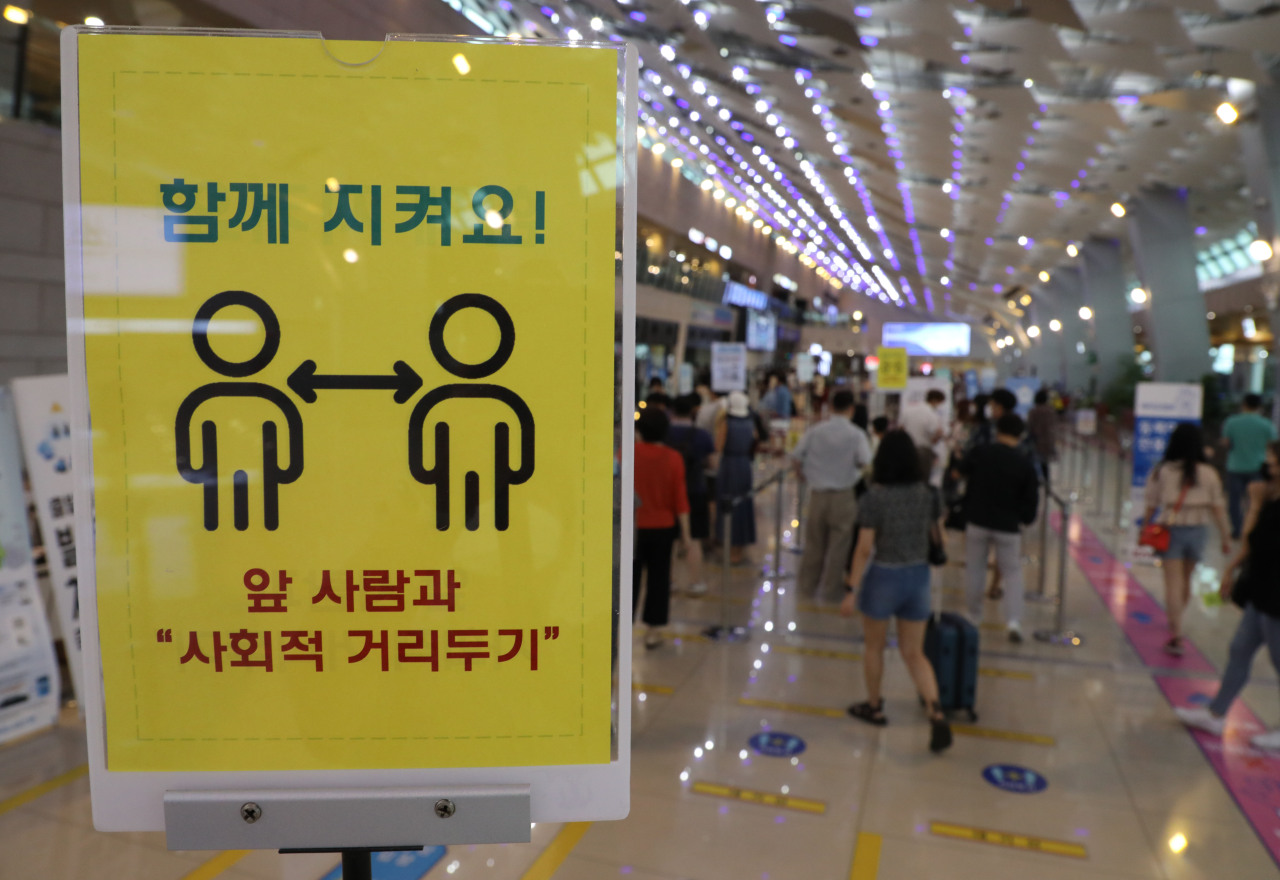 A notice, which asks people to maintain social distancing amid the coronavirus pandemic, is posted at Gimpo airport in Seoul on Thursday. (Yonhap)