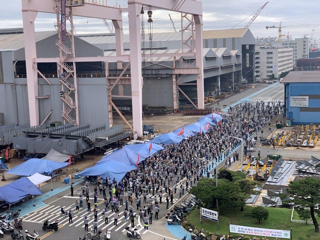 Unionized workers gather under a shipbuilding crane at the shipyard of Hyundai Heavy Industries Co. in Ulsan, 414 kilometers southeast of Seoul, which has been occupied by Cho Kyung-guen, the head of the shipbuilder's labor union, in this photo provided by the union on Friday. (Hyundai Heavy Industries Co. Labor Union)