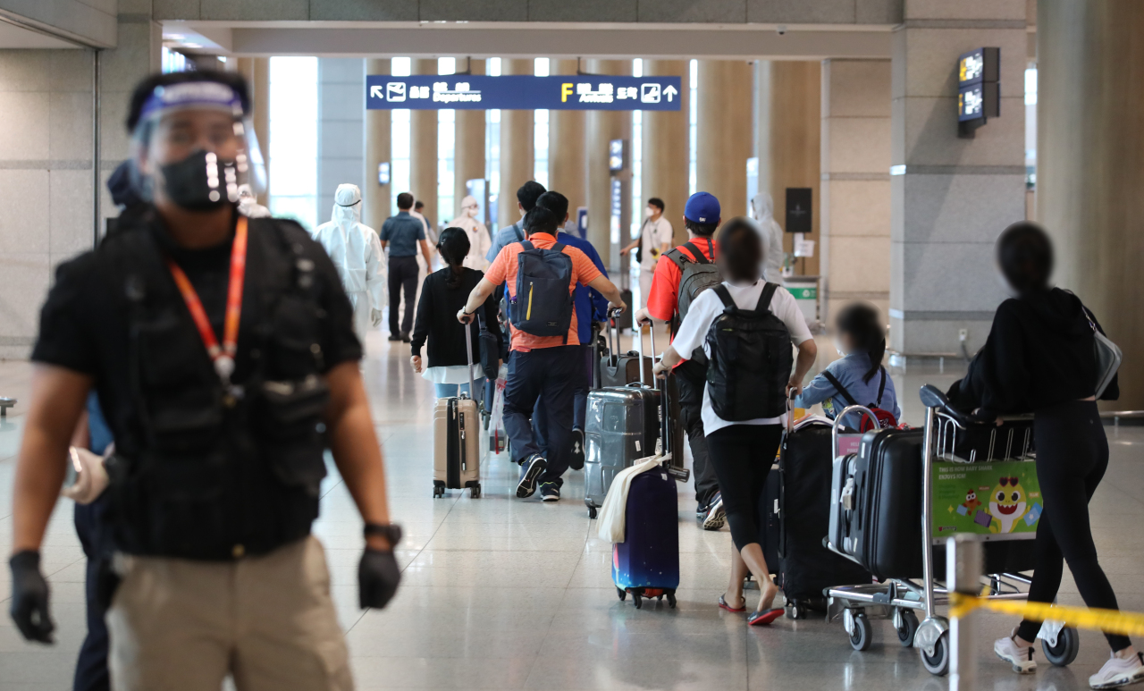 South Korean residents from India wait in a line at Incheon International Airport, west of Seoul, on Tuesday. (Yonhap)