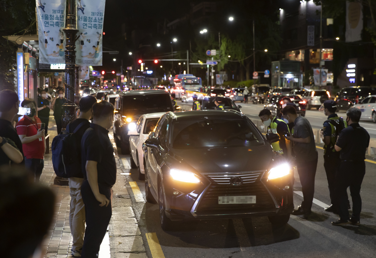 Small business owners hold a drive-through rally in protest of the government's COVID-19 restrictions in Daehangno, Seoul, early on Thursday. (Yonhap)