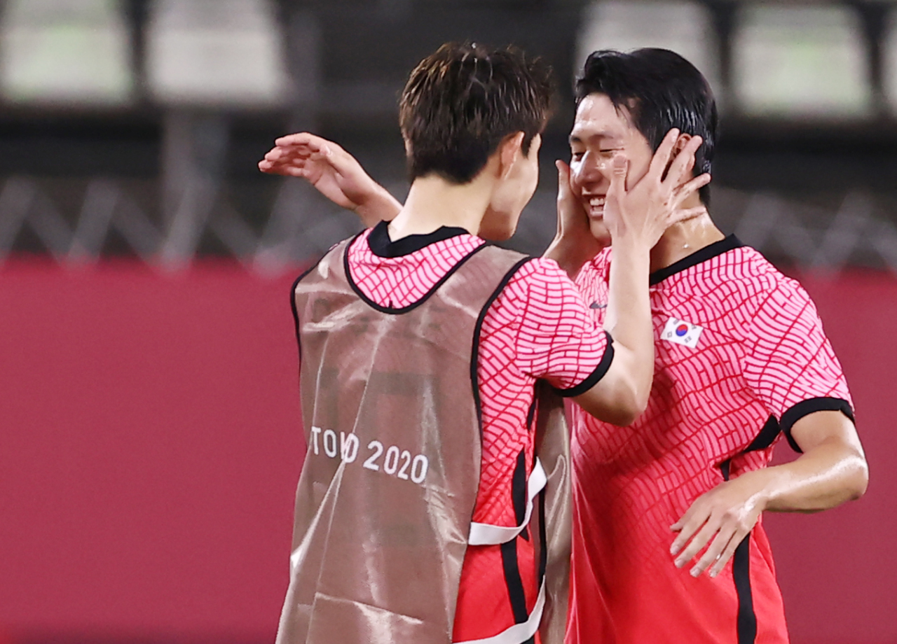 South Korean midfielder Lee Kang-in (right) is greeted by his team colleague Lee Dong-kyung after South Korean national team beat Romania 4-0 in Tokyo Olympics on Sunday. (Yonhap)