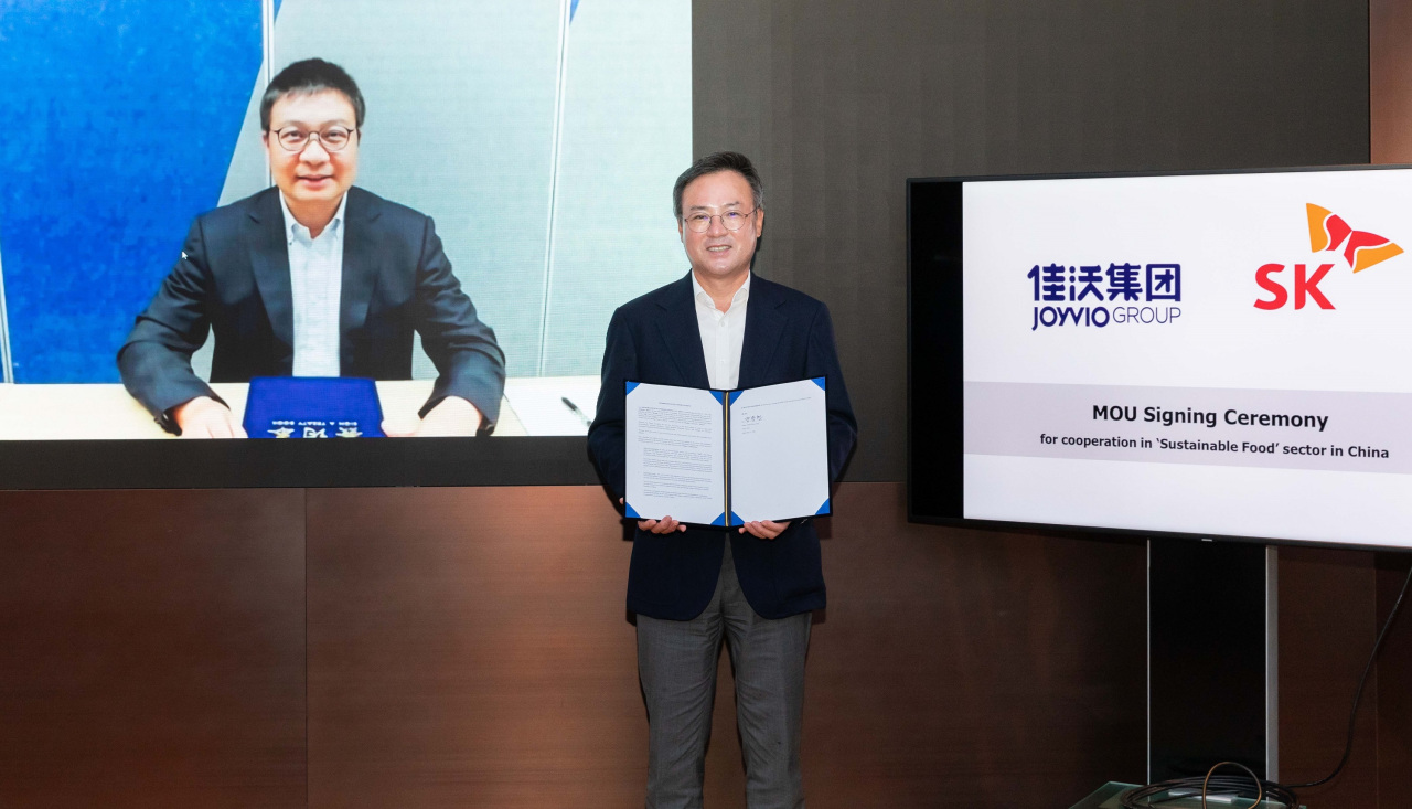 SK Inc. CEO Jang Dong-hyun (right) and Joyvio Group CEO Chen Shaopeng sign an agreement to form a 100 billion-won fund to invest in China’s alternative food market. (SK)