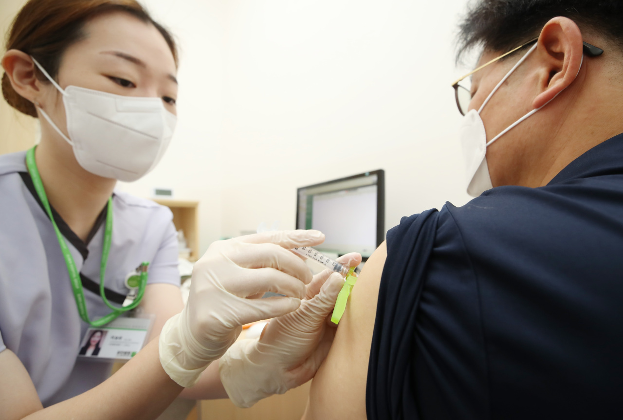A man receives a COVID-19 vaccine shot at a medical facility in Seoul on Monday, as health authorities started a program the same day to inoculate people aged from 55 through 59 across the country. (Yonhap)
