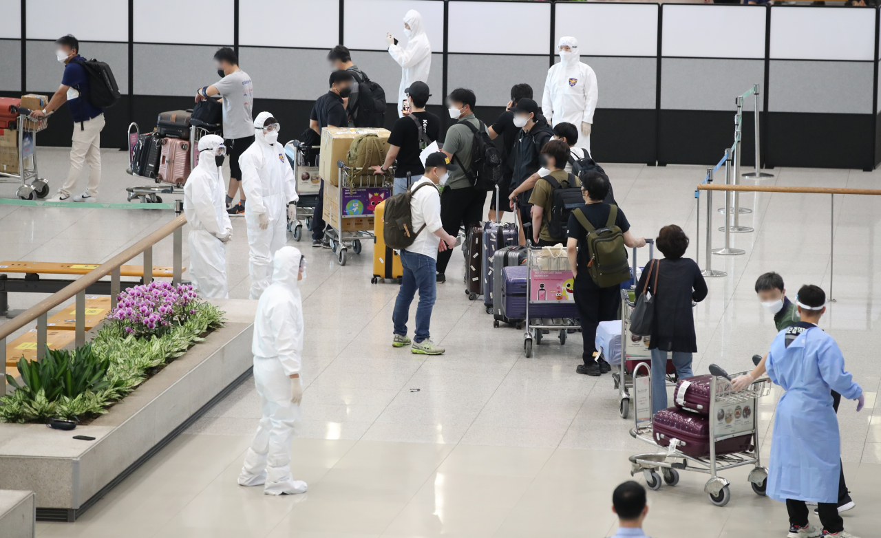 South Korean residents and diplomats from India are guided by quarantine officials upon arrival at Incheon International Airport, west of Seoul, on July 13, 2021, amid the fourth wave of COVID-19. (Yonhap)