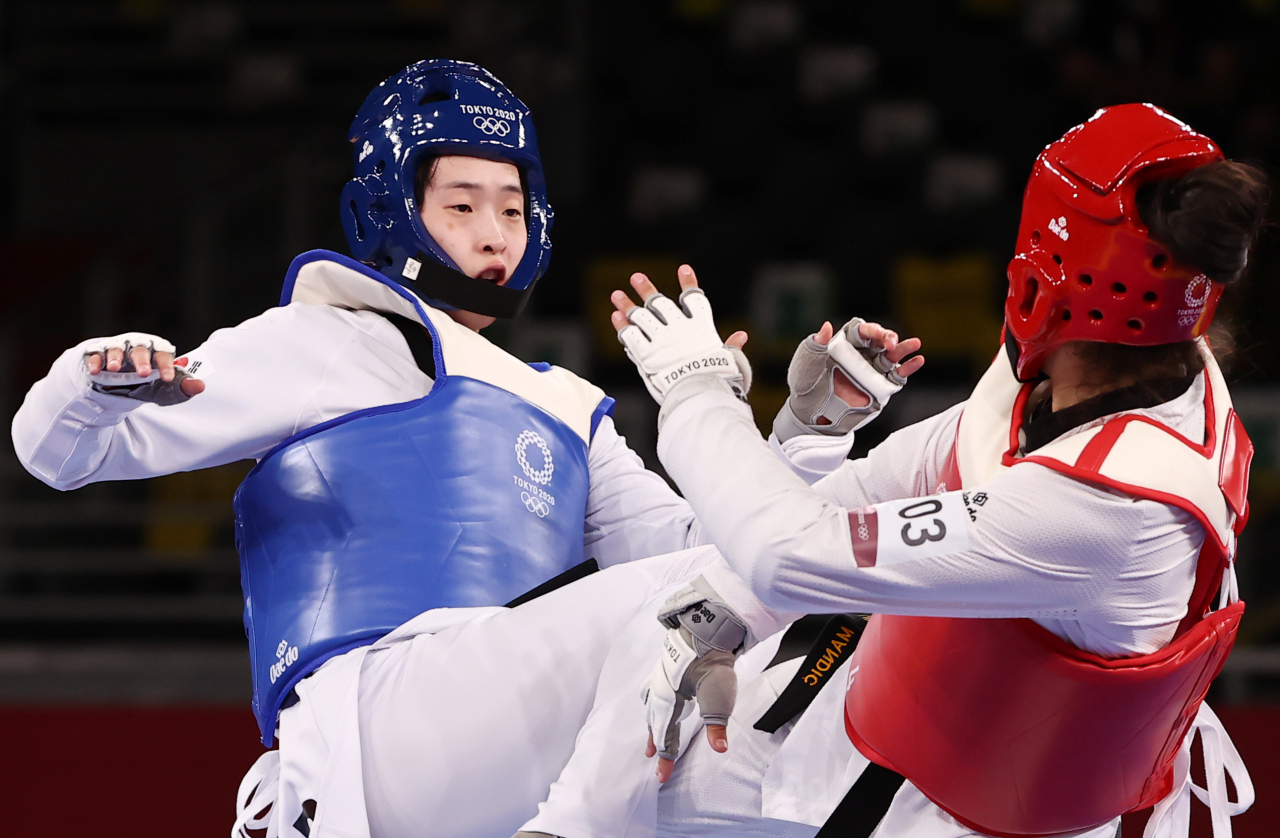 Lee Da-bin of South Korea (left) fights Milica Mandic of Serbia in the final of the women's +67kg taekwondo event at Makuhari Messe Hall A in Chiba, Japan, on Tuesday. (Yonhap)