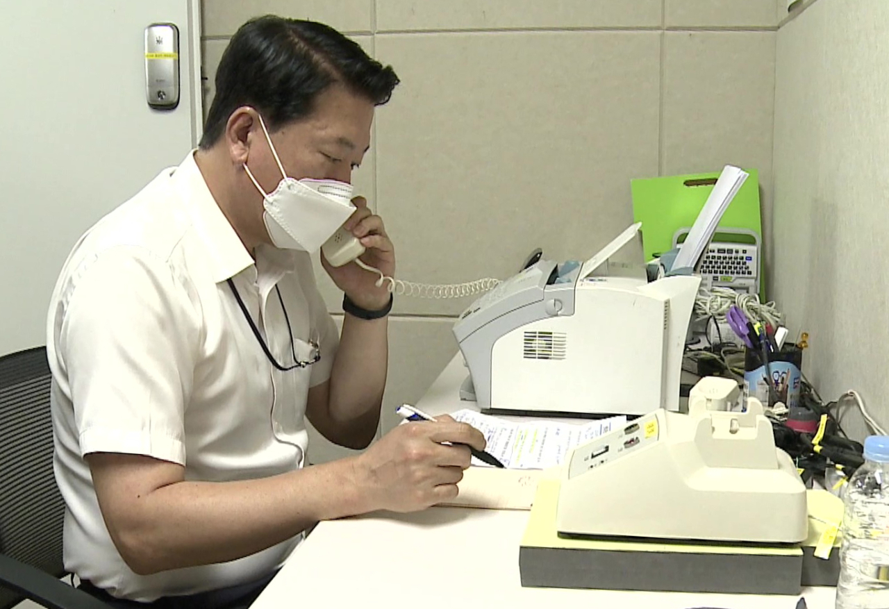 This photo, provided by the unification ministry, shows a South Korean liaison officer talking to his North Korean counterpart at the Seoul bureau of their joint liaison office on Tuesday. After a 13-month suspension, the two Koreas restored cross-border communication lines that Pyongyang severed last year in protest of propaganda leaflets coming in from the South. (Unification Ministry)