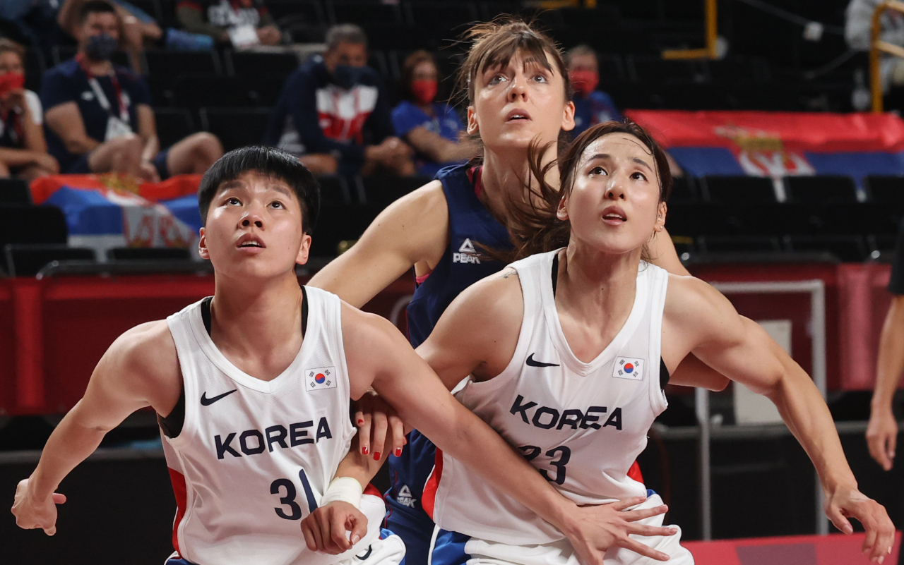 Jin An (L) and Kim Danbi of South Korea try to box out a Serbian player during the teams' Group A game in the Tokyo Olympic women's basketball tournament at Saitama Super Arena in Saitama, Japan, on Sunday. (Yonhap)