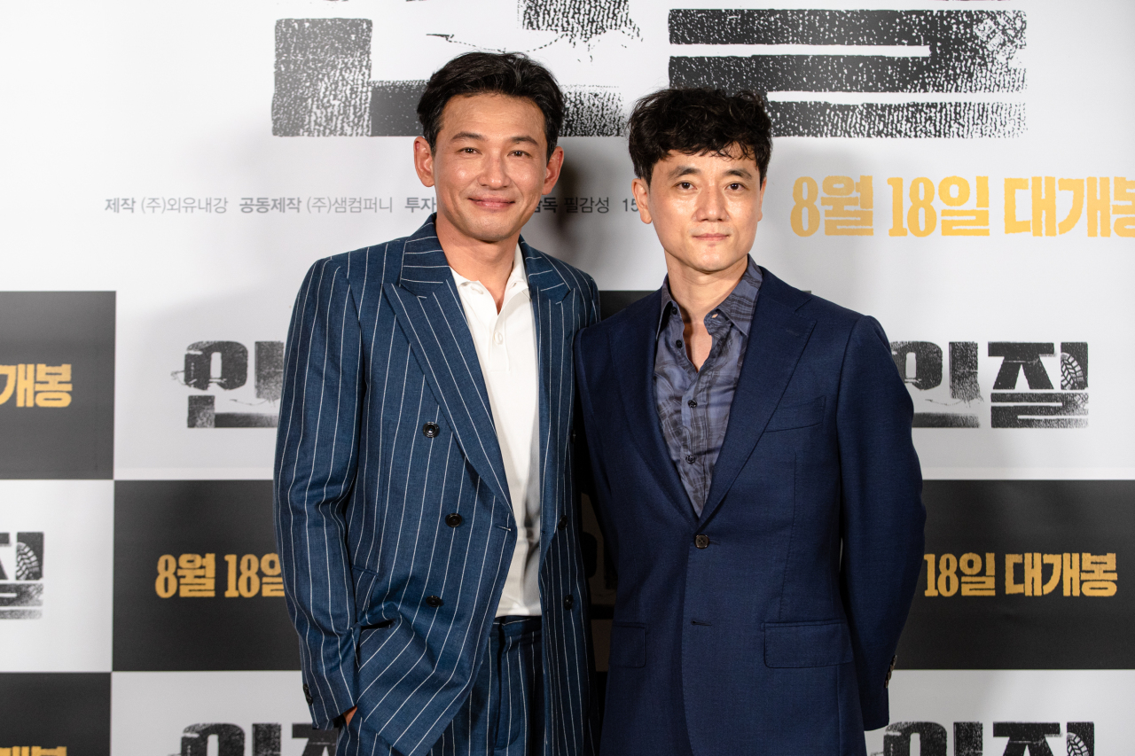 Actor Hwang Jung-min (left) and director Pil Gam-seong pose for photos after a press preview of “Hostage: Missing Celebrity” held on Thursday. (New)