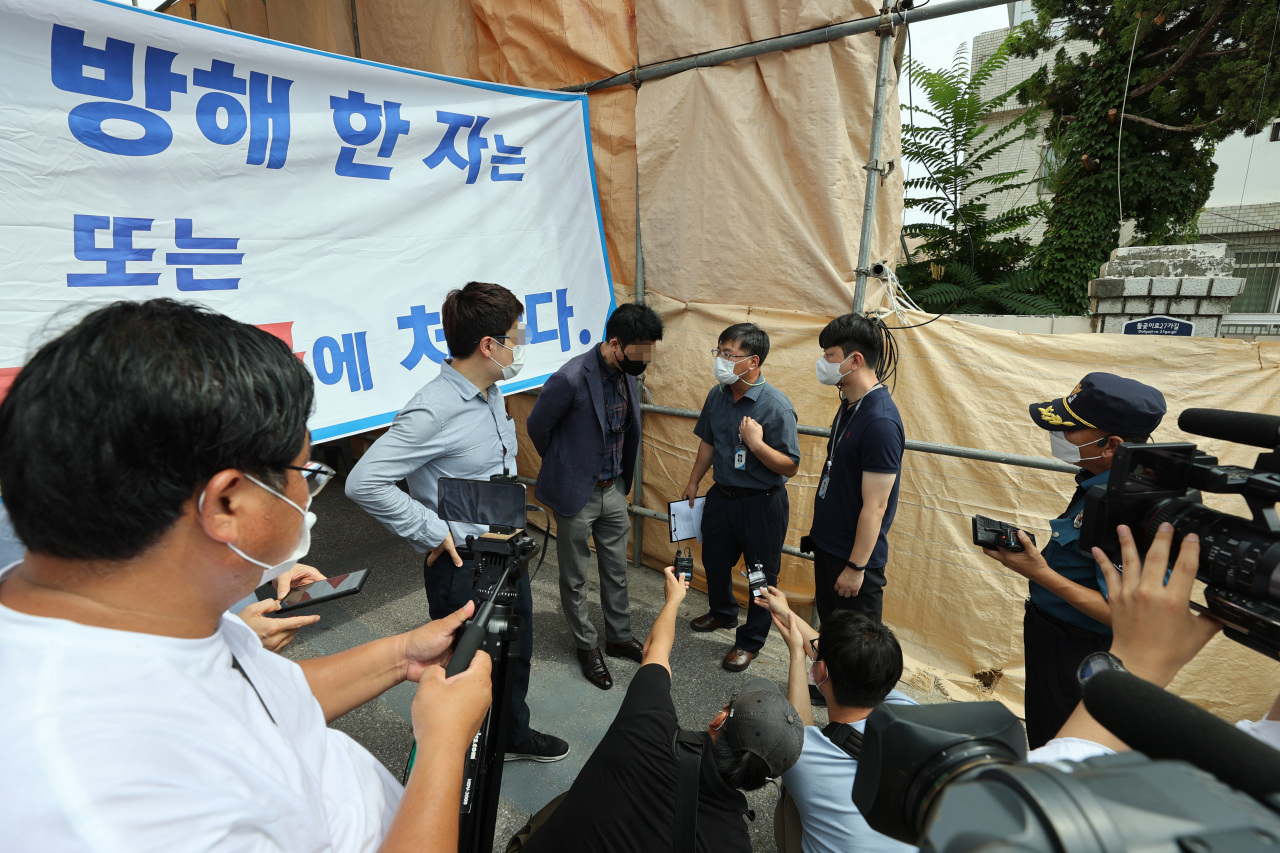 Church lawyers block the path of officials from Seongbuk-gu Office who went to the church on Sunday to monitor compliance with quarantine rules. (Yonhap)