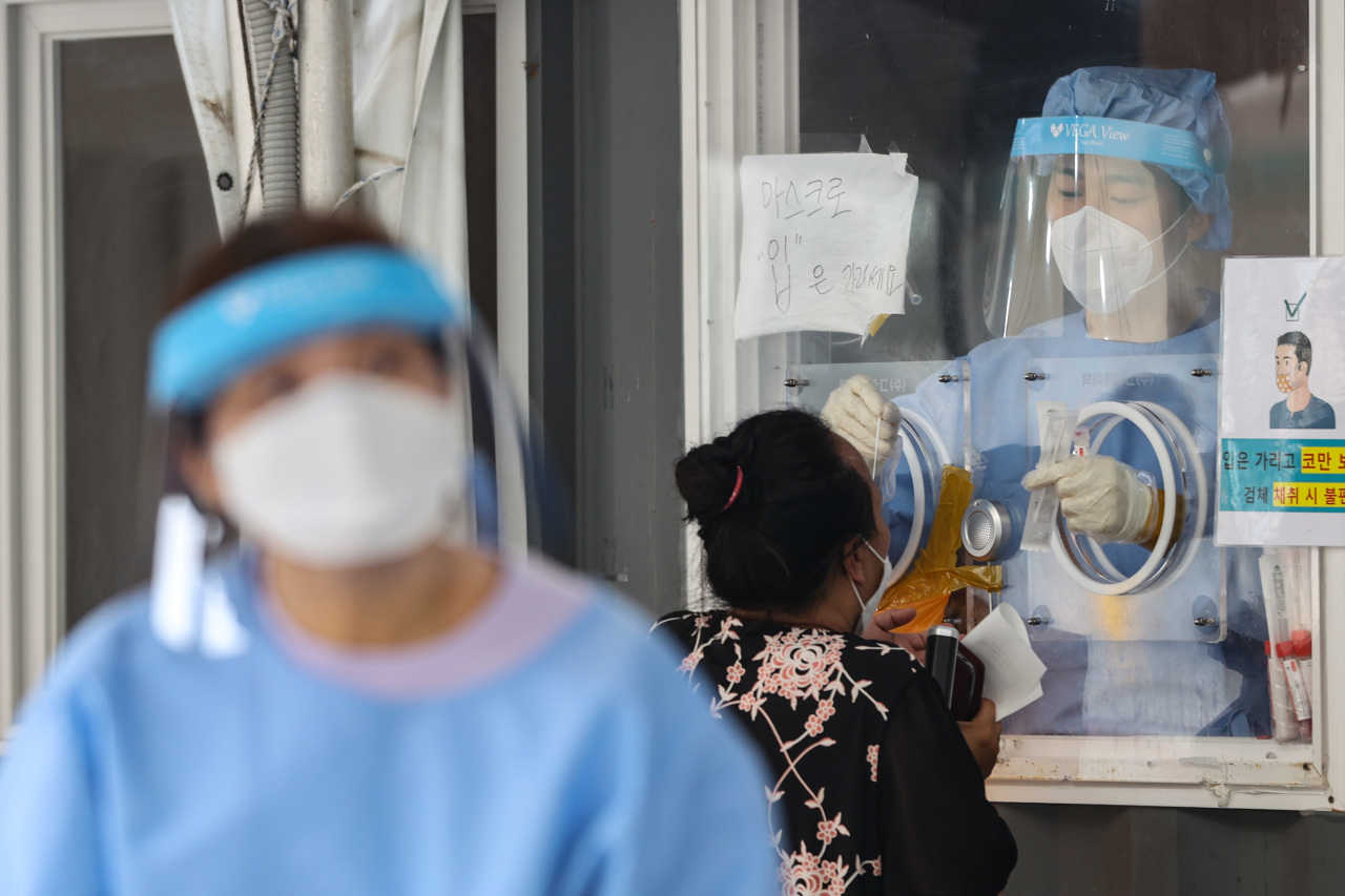 Medical personnel collect samples at a temporary screening laboratory in Seoul Station Square on Wednesday morning. (Yonhap)
