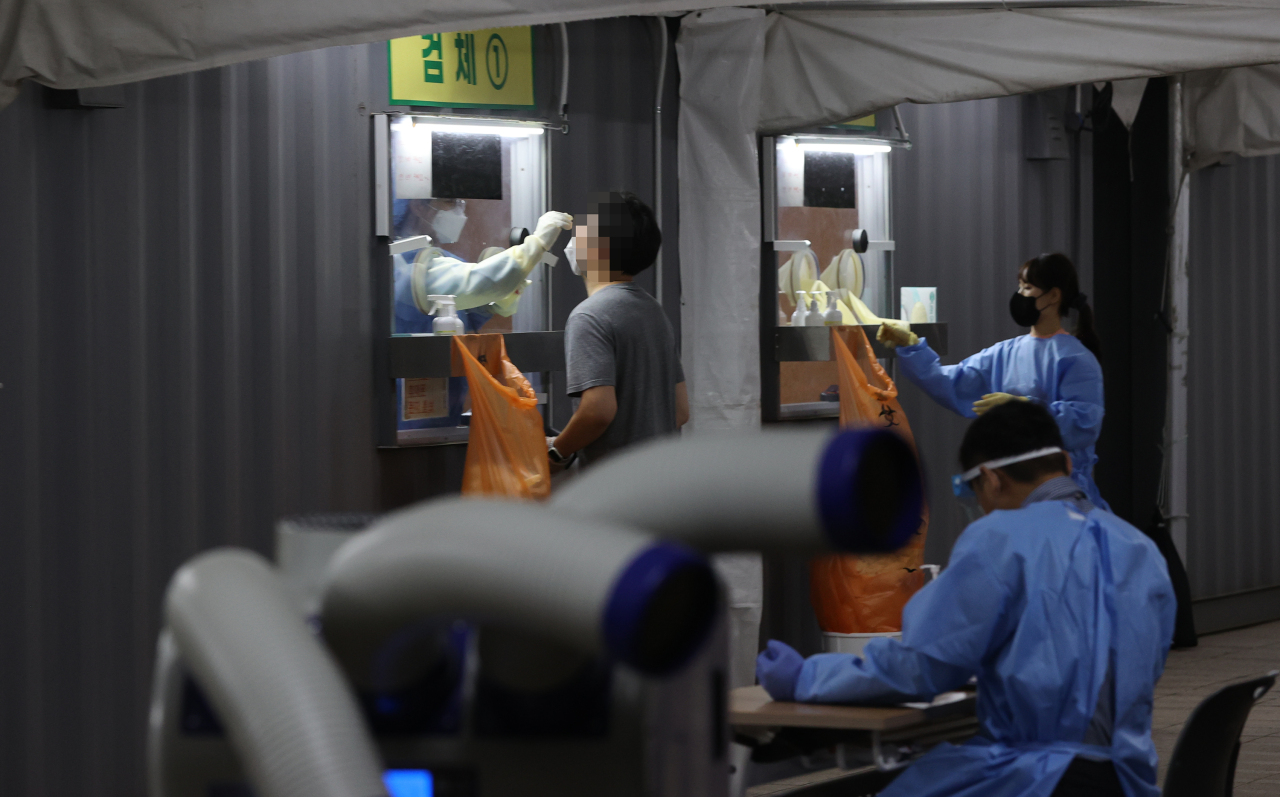 A person takes a virus test at a screening center set up at Seoul Plaza in downtown Seoul on Wednesday, when daily confirmed cases surpassed 2,000 for the first time since the outbreak of the infections on Jan. 20, 2020. (Yonhap)