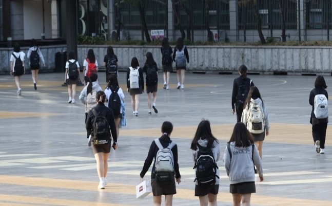 Students go to school in downtown Seoul, where school started after summer vacation, on Tuesday. (Yonhap)