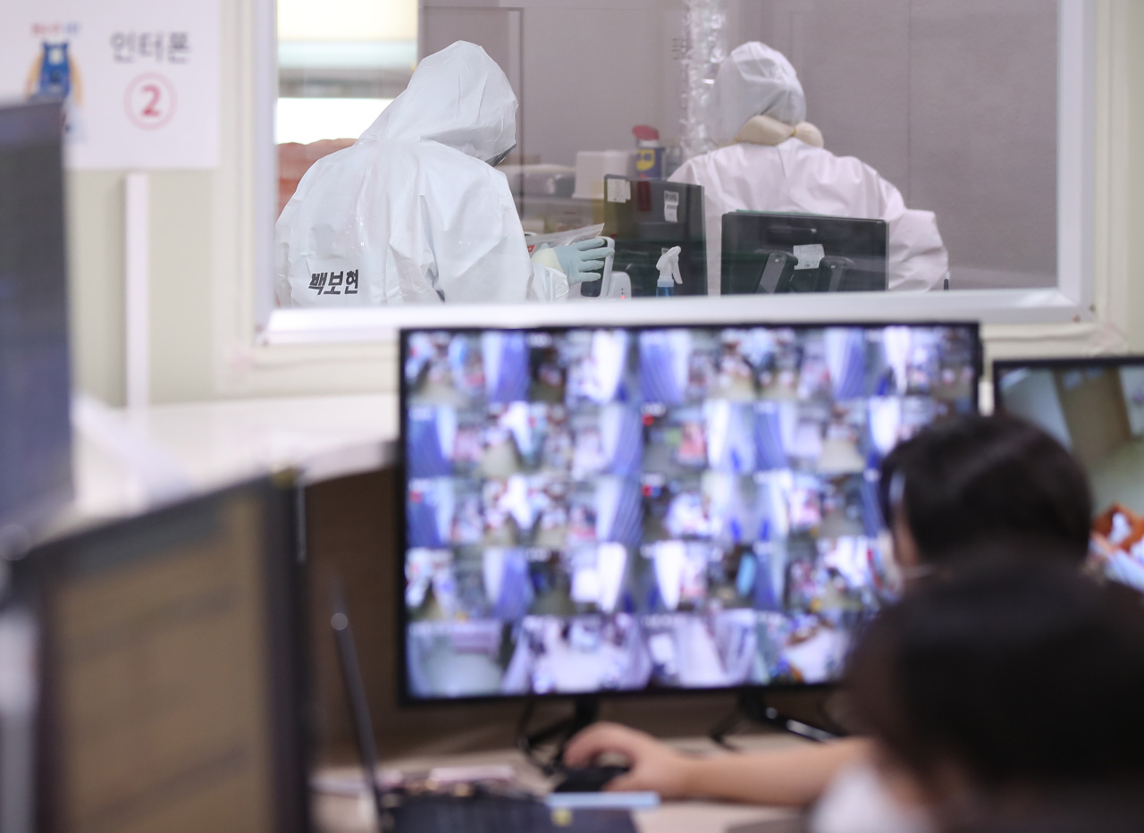 Medical staffers monitor patients in a COVID-19 ward at a public hospital in Goyang, Gyeonggi Province, on Friday. (Yonhap)