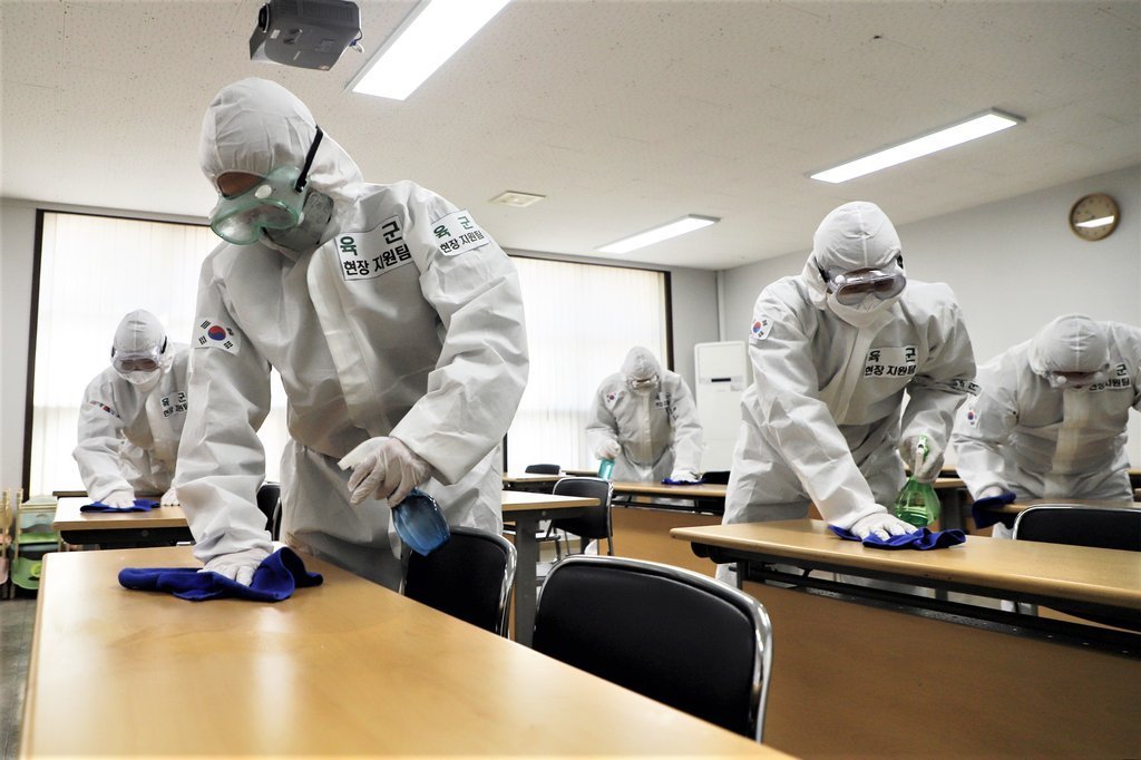 This undated file photo shows service members disinfecting a military facility. (Yonhap)