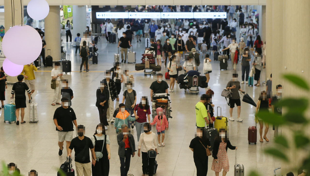 This photo, taken on Saturday, shows travelers at an international airport in the southern resort island of Jeju as the three-day Liberation Day-related holiday period started amid the pandemic. (Yonhap)