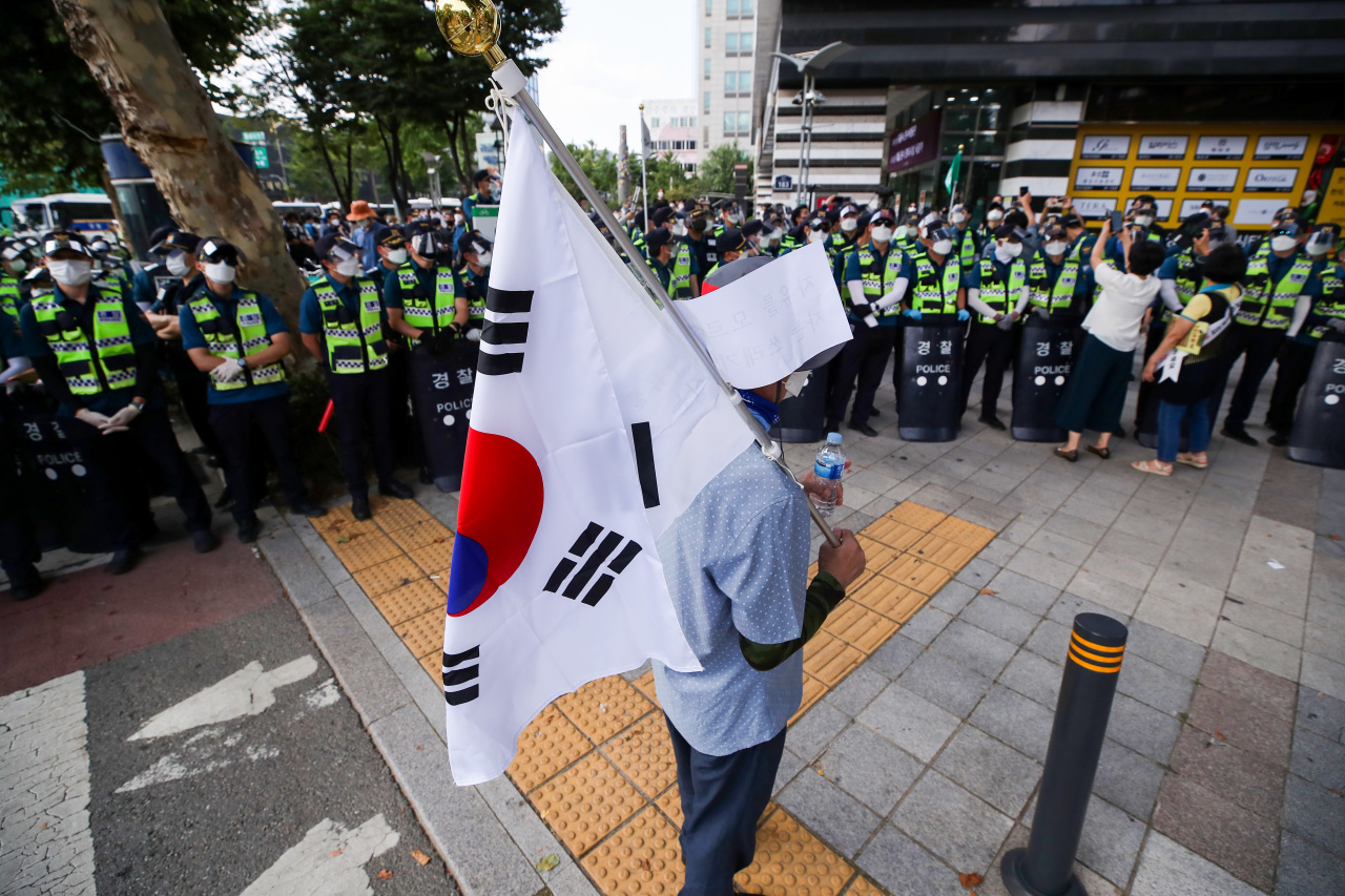 Police surround a lone protester in Jongno, central Seoul, on Sunday. (Yonhap)
