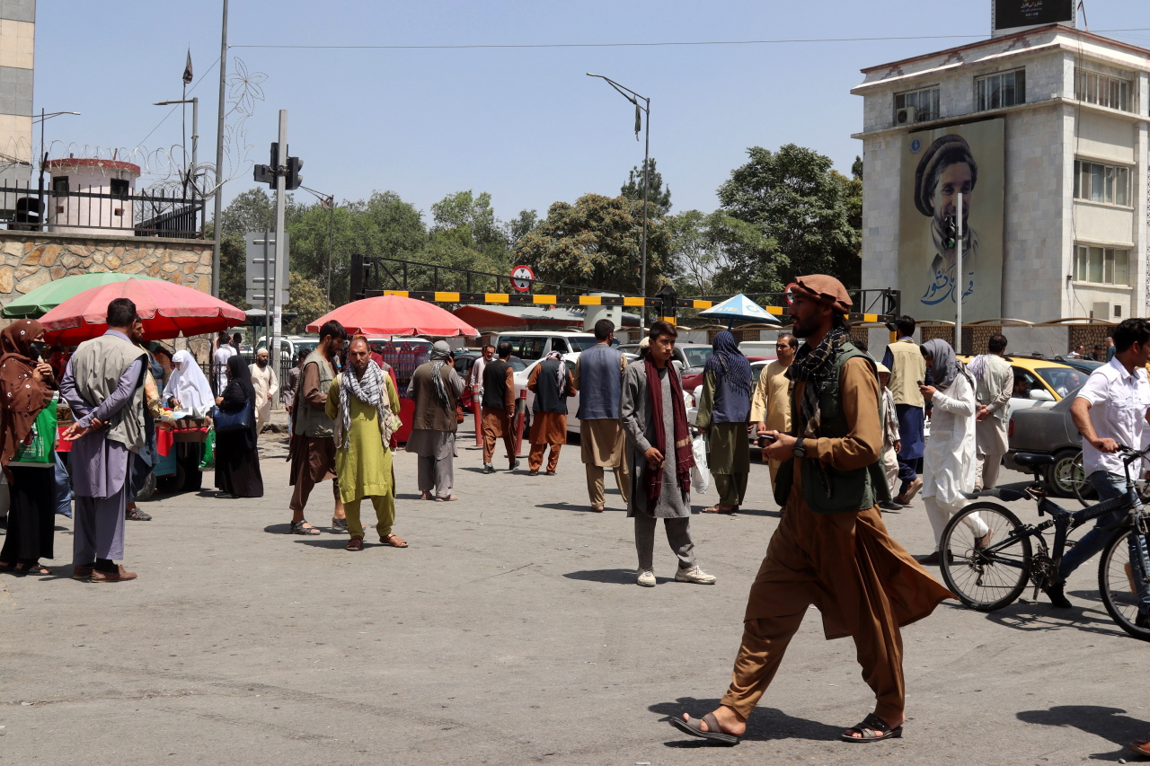 Afghans who work at different offices rush to homes after news broke that Taliban reached on the outskirts of Kabul, in Kabul, Afghanistan, Sunday. (EPA-Yonhap)