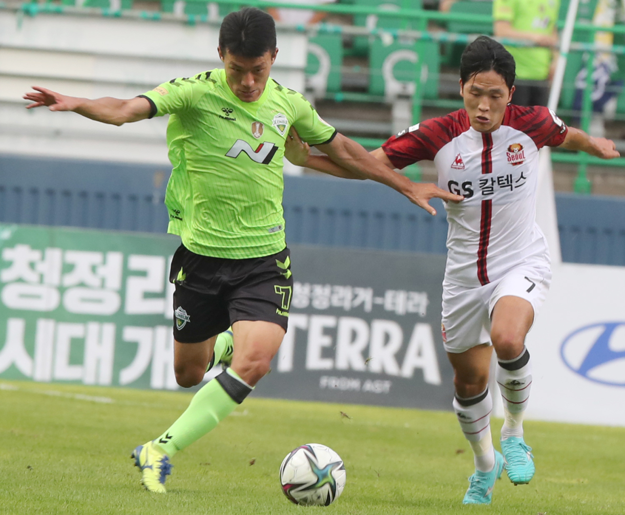 Han Kyo-won of Jeonbuk Hyundai Motors (L) tries to dribble past Na Sang-ho of FC Seoul during the clubs' K League 1 match at Jeonju World Cup Stadium in Jeonju, 240 kilometers south of Seoul, on Friday. (Yonhap)