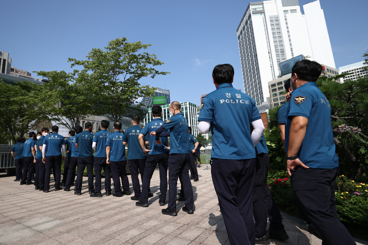 This photo taken on Monday, shows police officers waiting to take a coronavirus test at a makeshift testing facility in downtown Seoul.(Yonhap)