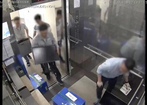 This file photo, provided by the Fair Trade Commission, shows Hyundai Heavy Industries Co.'s employees taking out the company's hard drives and computers in August 2018, ahead of the antitrust watchdog's on-site inspection over alleged unfair trade. (Fair Trade Commission)