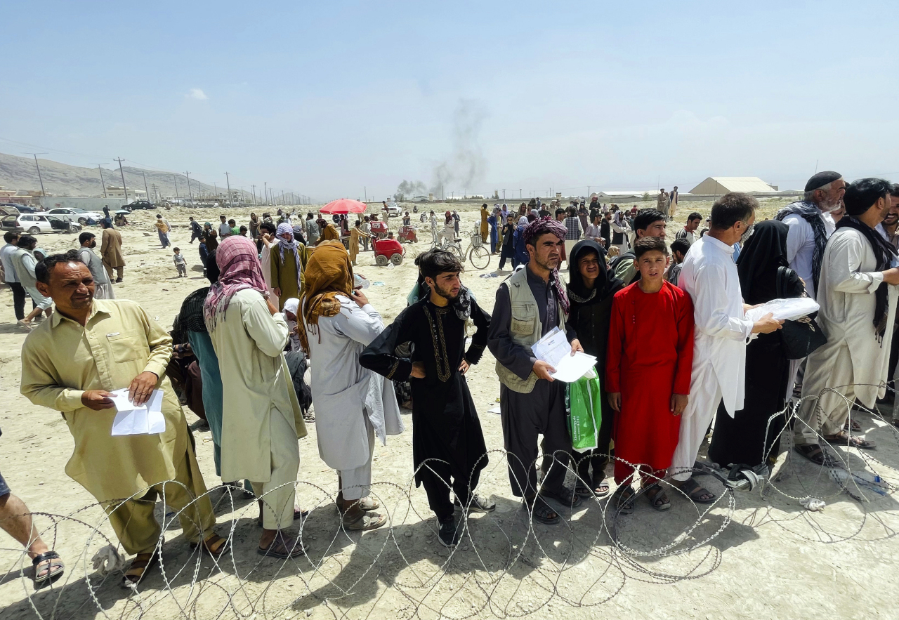 Hundreds of people gather outside the international airport in Kabul, Afghanistan, Tuesday. The Taliban declared an “amnesty” across Afghanistan and urged women to join their government Tuesday, seeking to convince a wary population that they have changed a day after deadly chaos gripped the main airport as desperate crowds tried to flee the country. (AP-Yonhap)