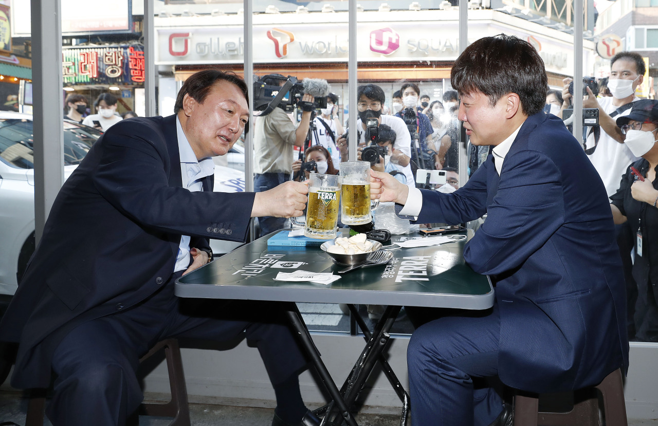 Former Prosecutor General Yoon Seok-youl (L) poses for a photo with Lee Jun-seok, leader of the main opposition People Power Party, as they meet at a restaurant in Seoul on July 25, 2021.  (Yonhap)