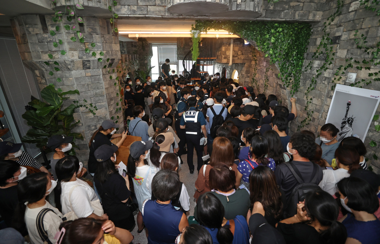 People line up in front of the headquarters of Mergeplus to demand a refund from the company in Seoul on Aug. 13. (Yonhap)