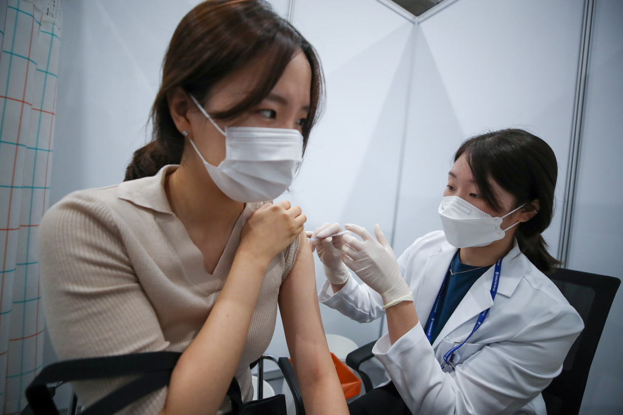 A medical personnel gives a COVID-19 vaccine shot to a woman in a vaccination center in western Seoul on Aug. 21, 2021. (Yonhap)