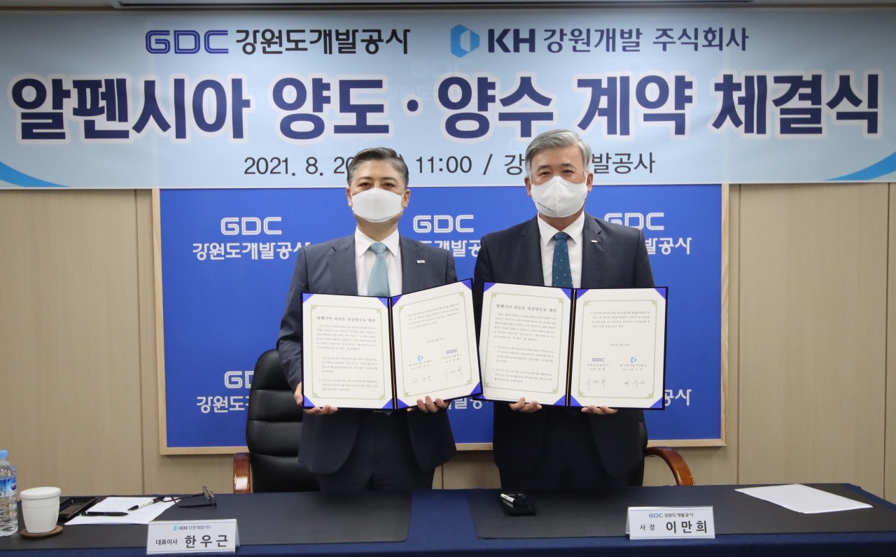 Han Woo-geun (left), CEO of KH Gangwon Development, and Gangwondo Development Corp. CEO Lee Man-hee pose for a photograph after signing the Alpensia deal. (KH Group)