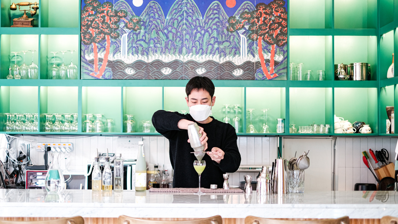A bartender presents traditional regional liquor-based cocktail (OneshotKorea)