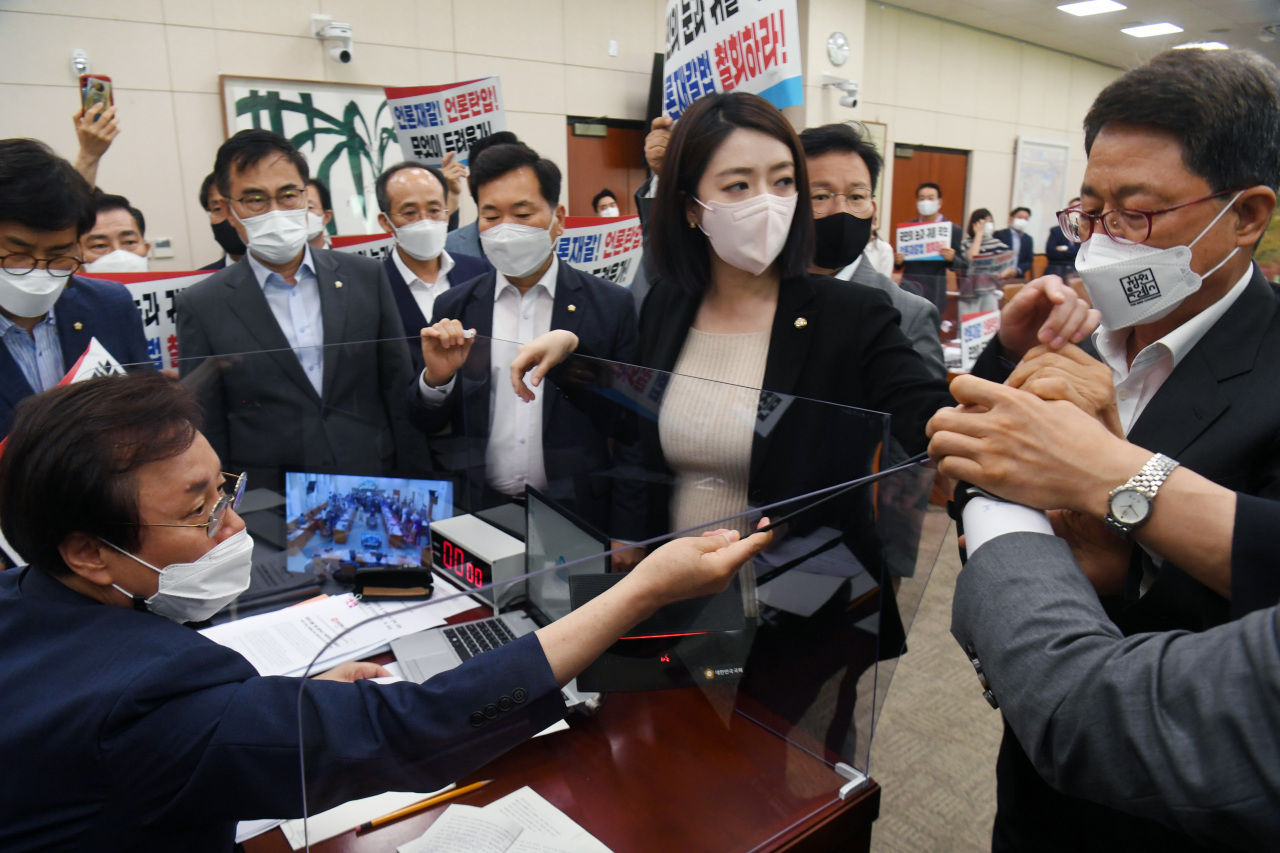 Lawmakers of the main opposition People Power Party storm the podium of Do Jong-hwan, chief of the culture, sports and tourism committee, during the committee's plenary meeting at the National Assembly in Seoul last Thursday, as they attempt to foil the ruling Democratic Party's push to enact a media arbitration bill that critics say will threaten people's right to know and discourage the press's checks on power. (Yonhap)