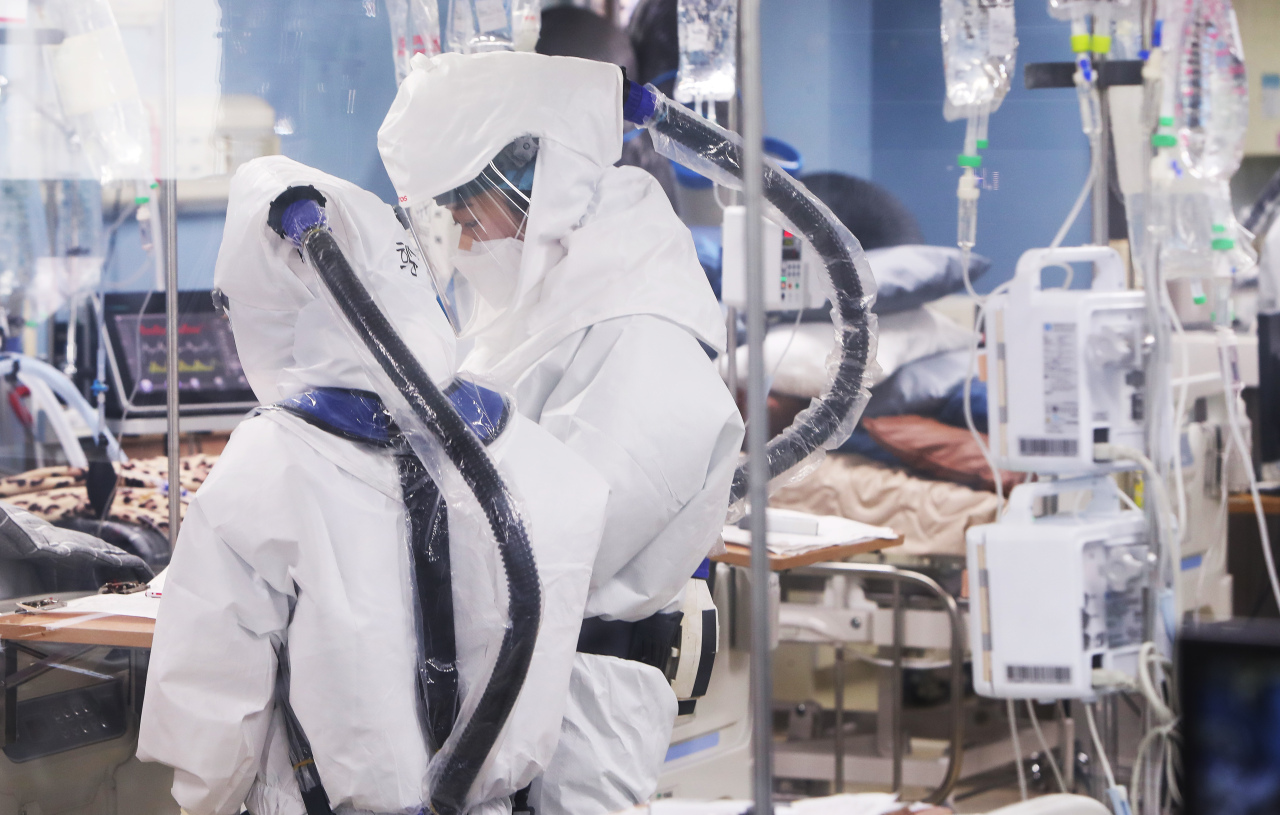 Photo shows health care workers in full-body protective suits inside a COVID-19 ward at a hospital in Pyeongtaek, Gyeonggi Province, on Friday. (Yonhap)