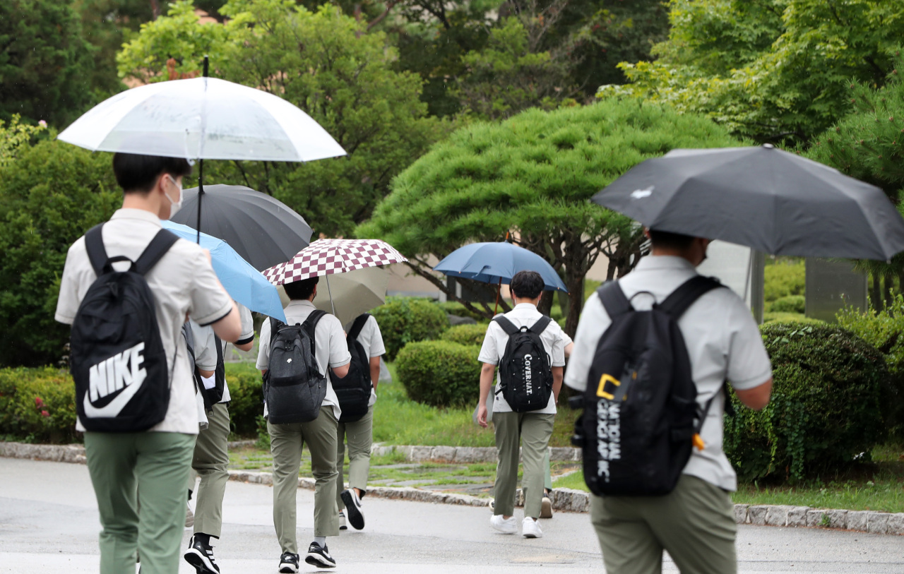 Photo shows students withing umbrellas in the rain at a high school in Chuncheon, Gangwon Province. (Yonhap)