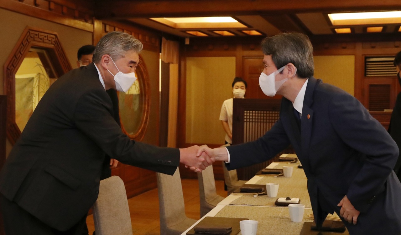 Unification Minister Lee In-young (right) shakes hands with US special representative for North Korea, Sung Kim ahead of their breakfast meeting in Seoul on Tuesday. (Unification Ministry)