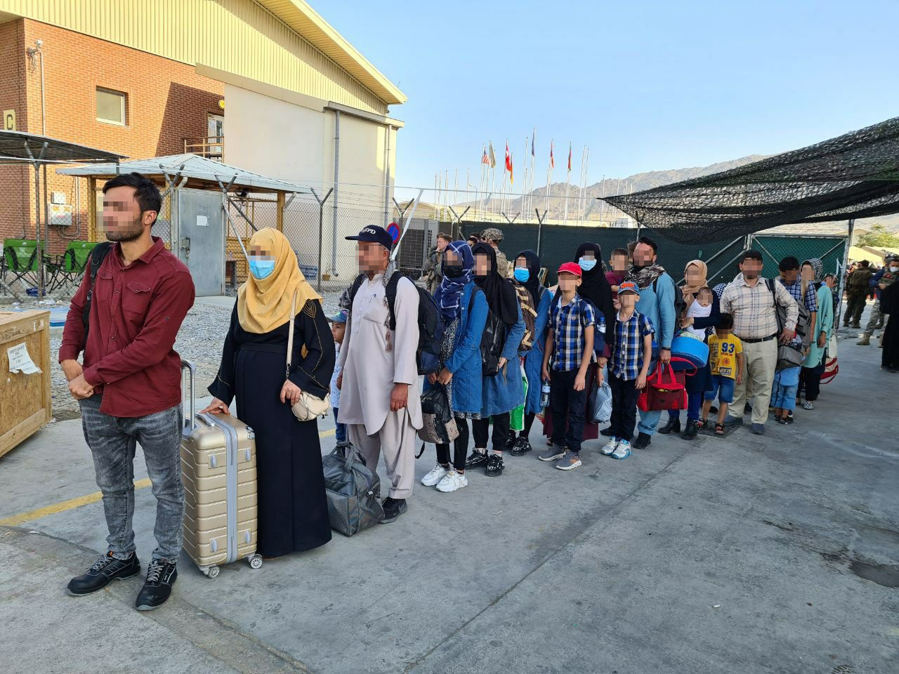 Afghans who have worked for the South Korean government in Afghanistan and their family members line up to board a South Korean military plane at an airport in Kabul, in this photo provided by the foreign ministry on Wednesday. (Yonhap)