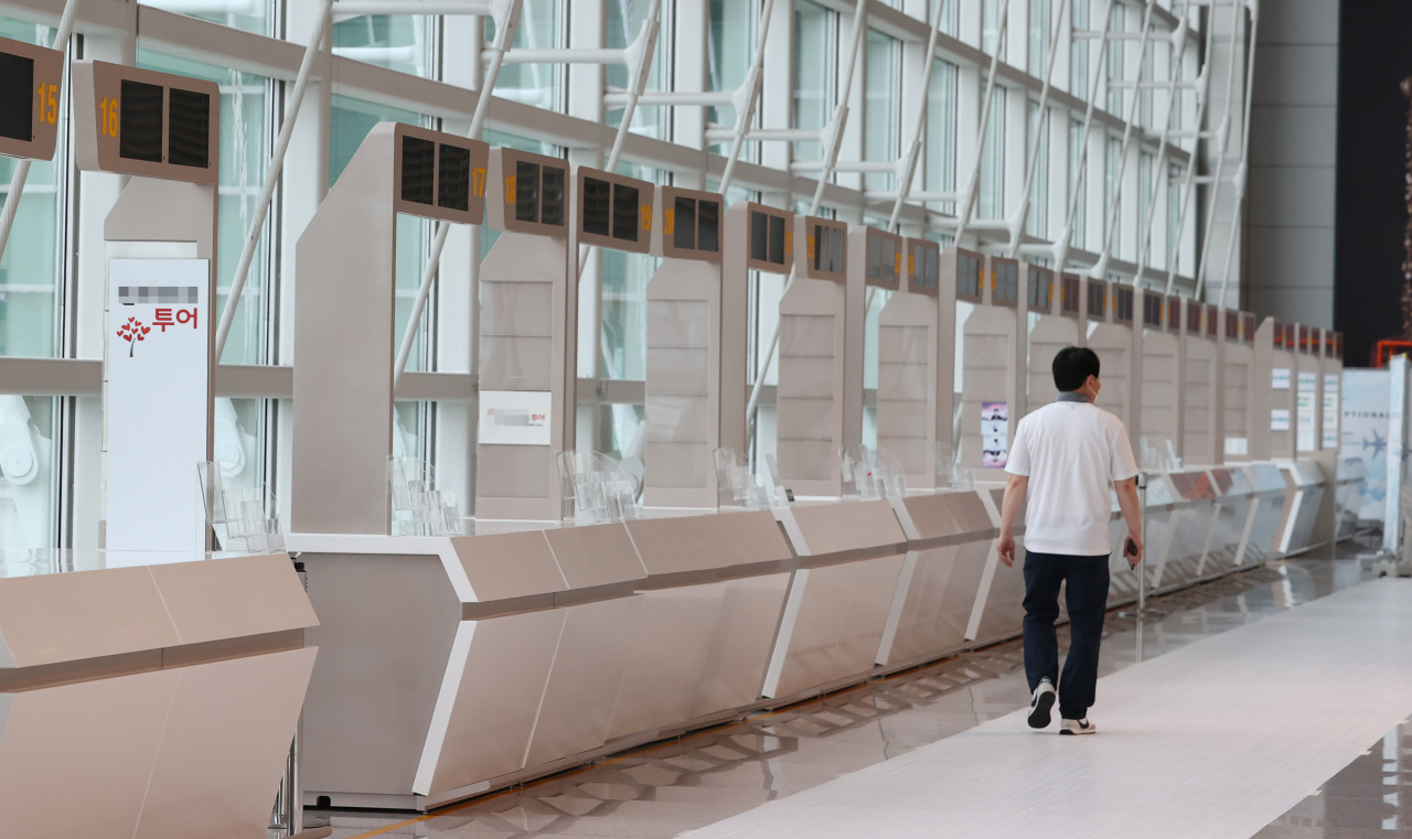 A man walks by unstaffed travel agency counters at Incheon Airport on Thursday. (Yonhap)