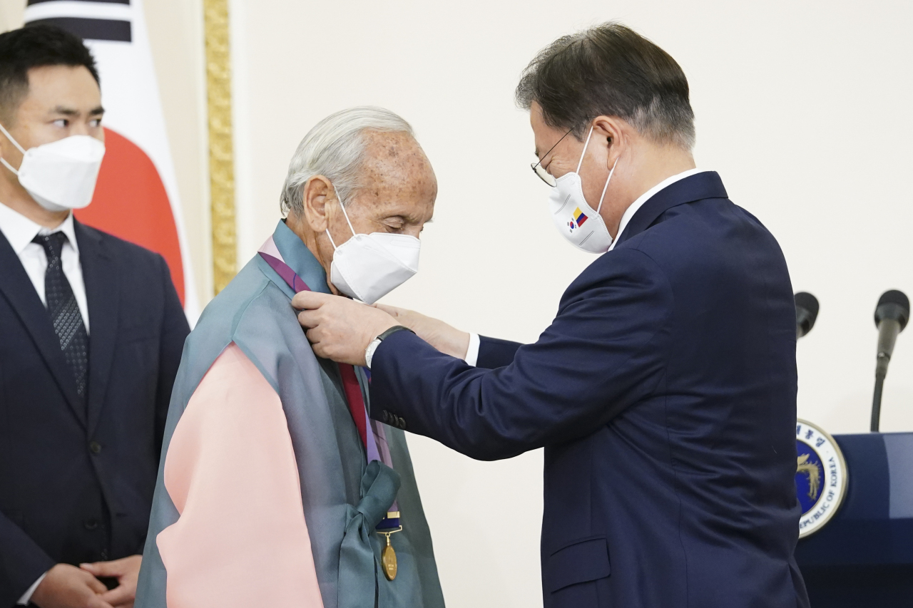 South Korean President Moon Jae-in (R) presents Alvaro Lozano Charry, a Colombian veteran of the Korean War, with the Ambassador for Peace Medal in Seoul on Wednesday, in this provided by his office. (Yonhap)