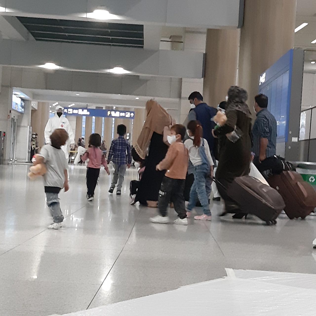 Afghan families walk toward the exit after passing immigration at Incheon Airport on Thursday evening. (Shin Ji-hye/The Korea Herald)