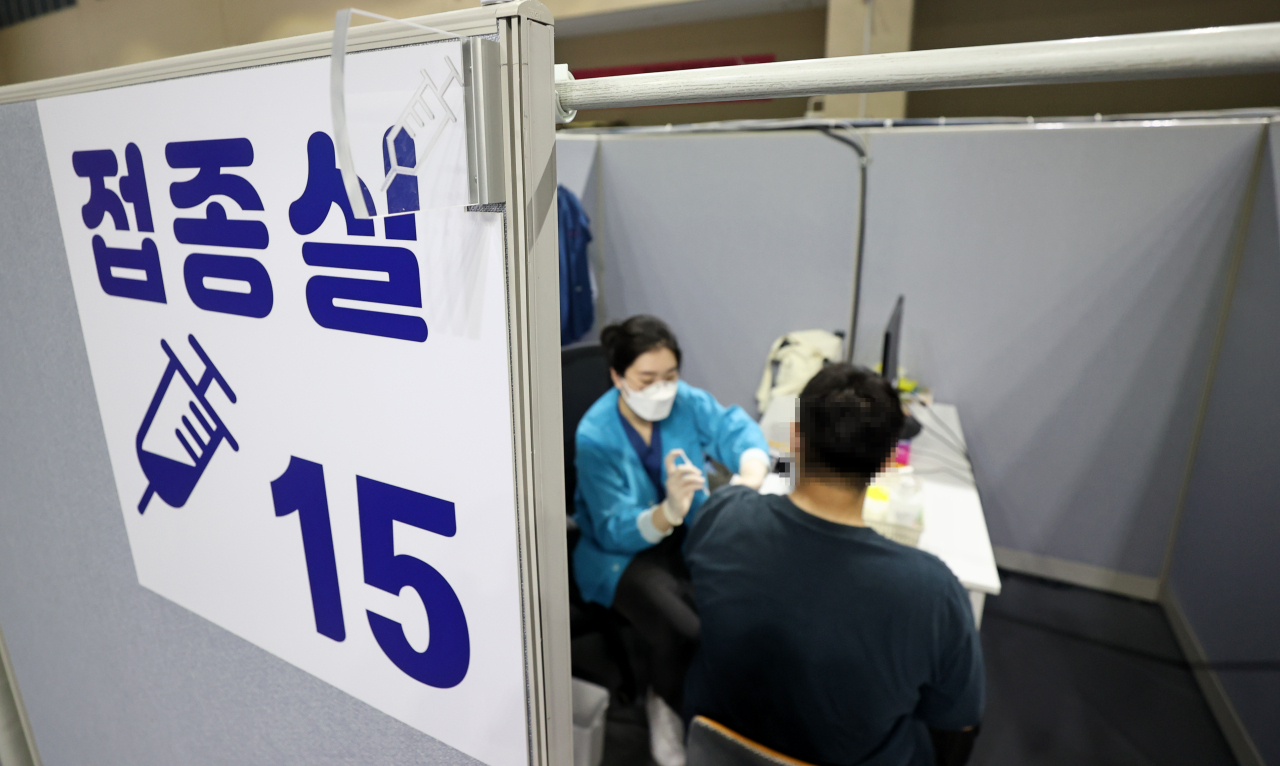 A visitor receives a COVID-19 jab at a makeshift inoculation center in southern Seoul on Monday. (Yonhap)